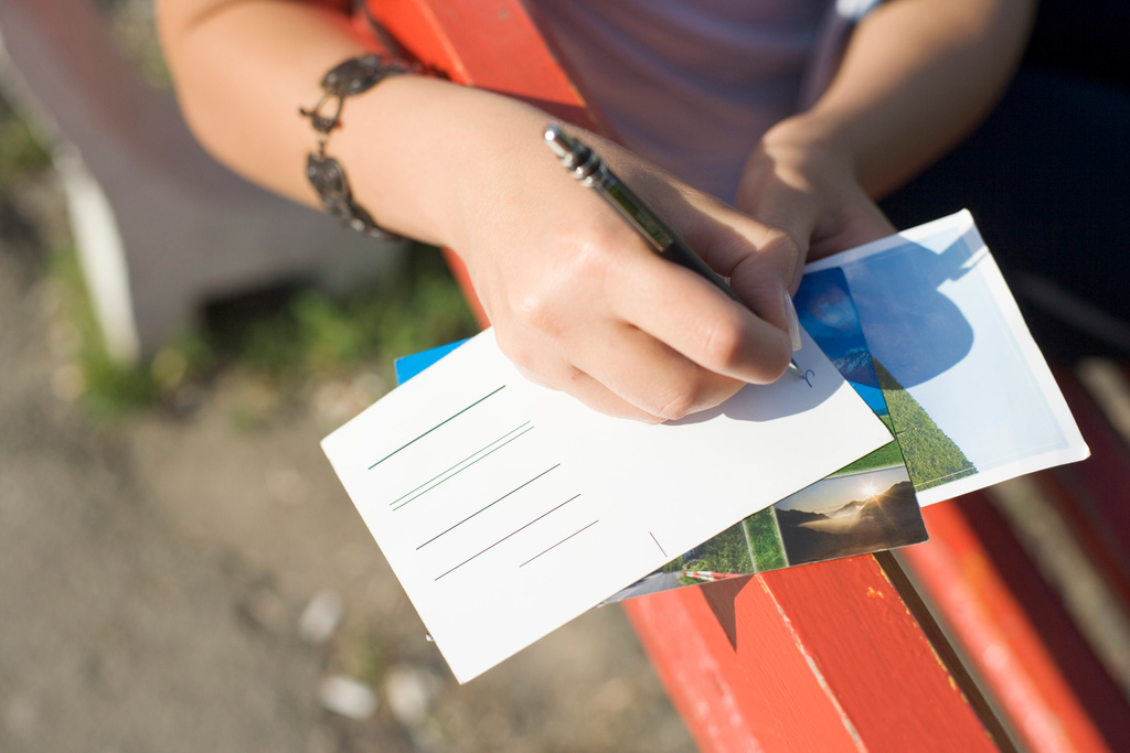 Woman writing on postcard